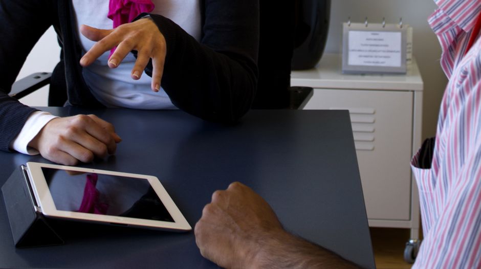 Therapist and client at a table with an iPad
